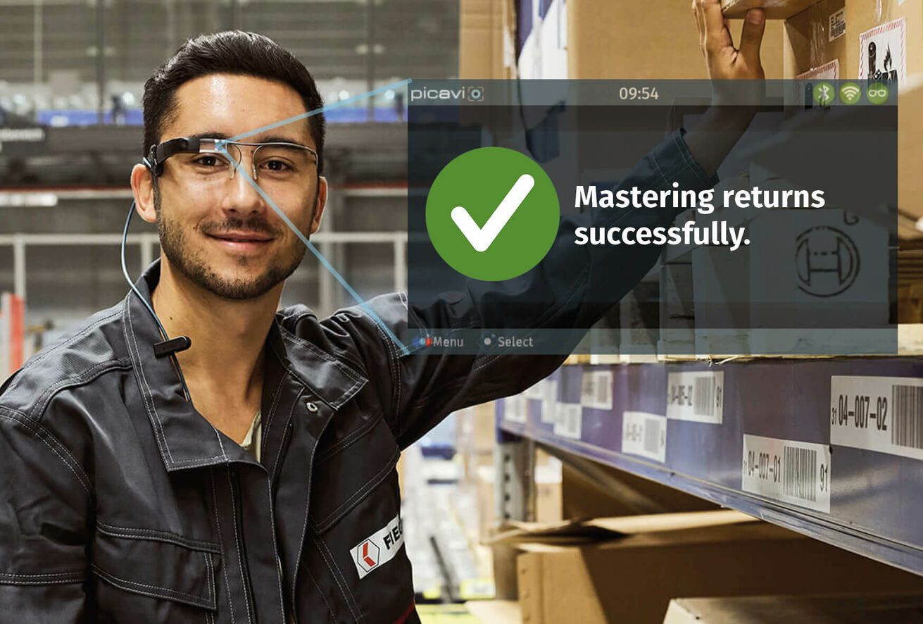 Picker at Fiege wearing Smart Glasses with the User Interface reading "Mastering returns successfully"